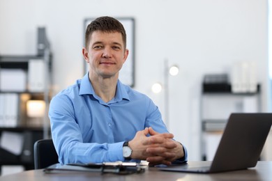 Photo of Portrait of handsome man at desk in office. Space for text