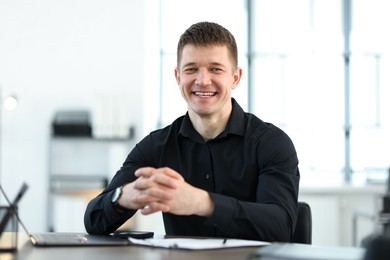Photo of Portrait of handsome man at desk in office