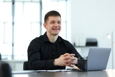 Photo of Portrait of handsome man at desk in office