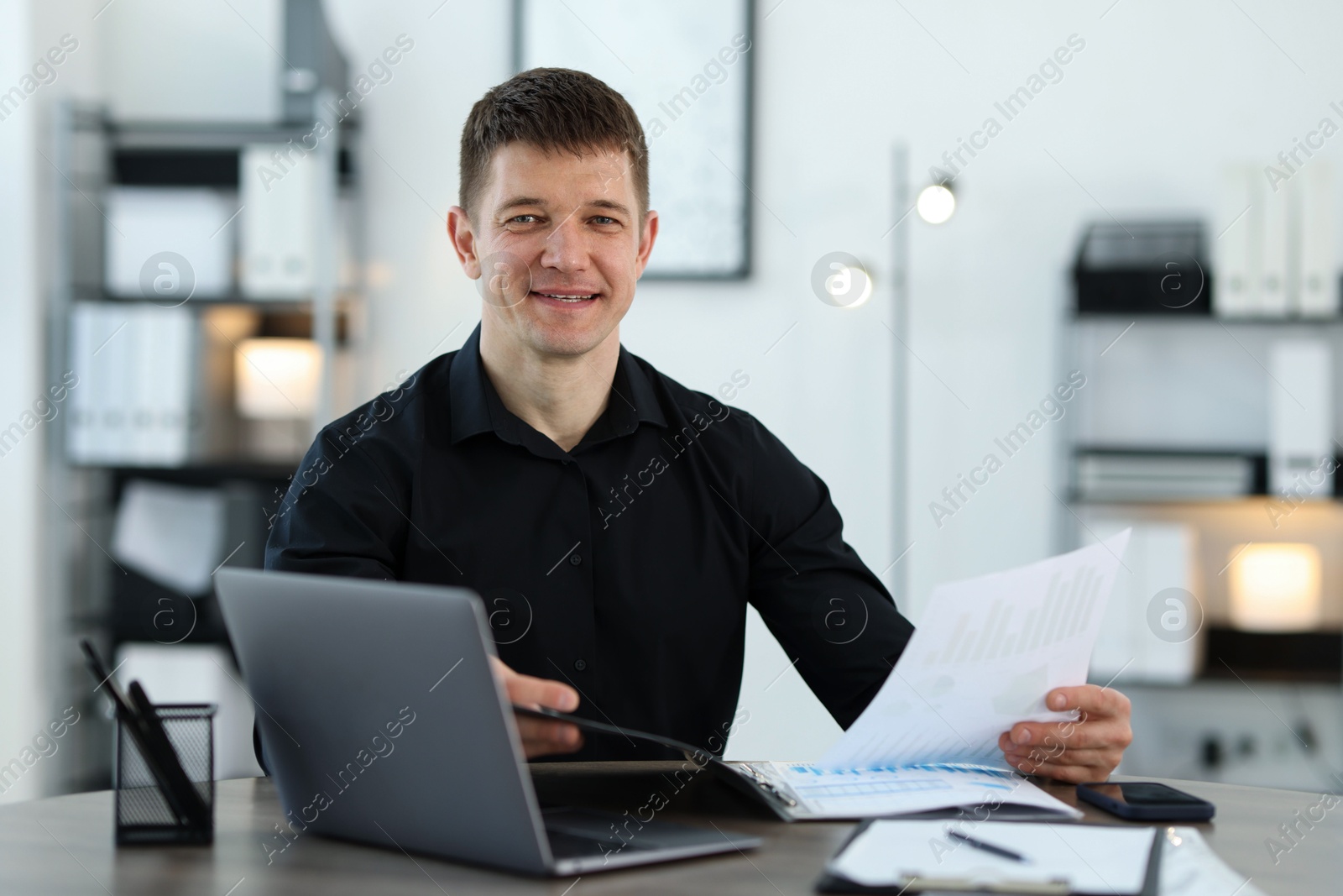 Handsome man working with documents at desk in office. Space for text Photo of Handsome man working with documents at desk in office. Space for text