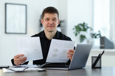 Photo of Handsome man working with documents at desk in office