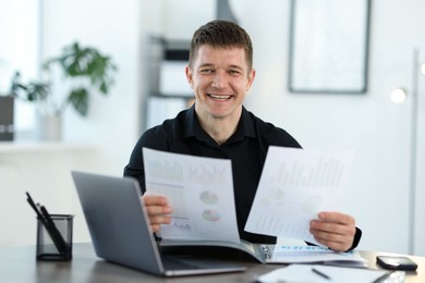Photo of Handsome man working with documents at desk in office