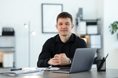 Photo of Portrait of handsome man at desk in office
