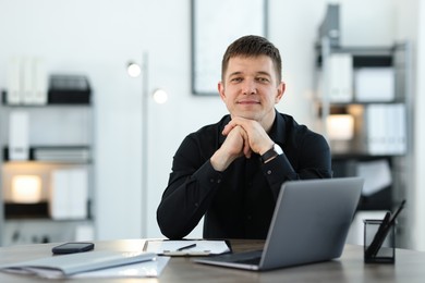 Photo of Portrait of handsome man at desk in office. Space for text
