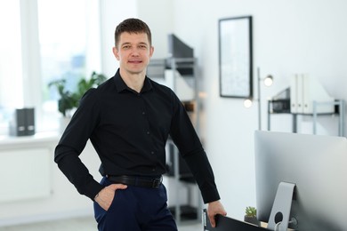 Photo of Portrait of handsome man near desk in office