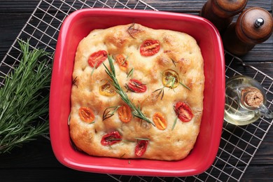 Photo of Delicious focaccia with tomatoes, spices and oil on table, flat lay