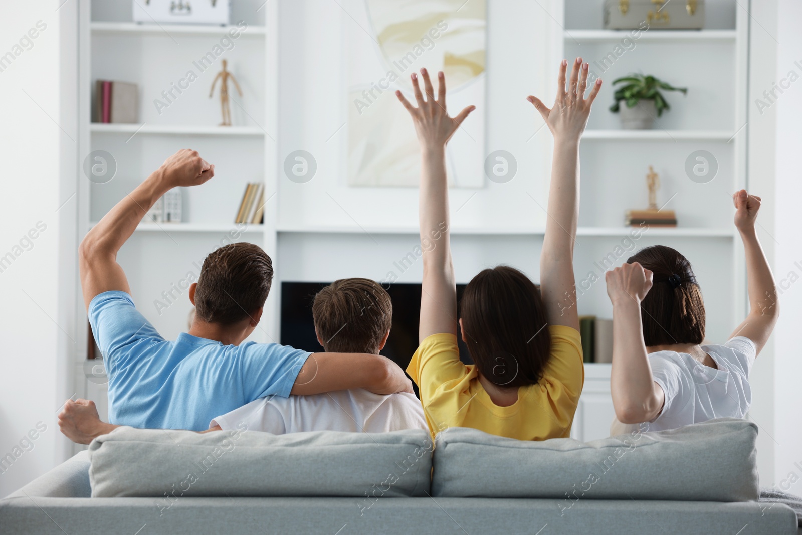 Group of football fans watching game together indoors, back view Photo of Group of football fans watching game together indoors, back view