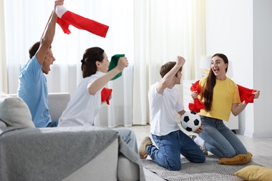 Photo of Emotional football fans watching game together indoors