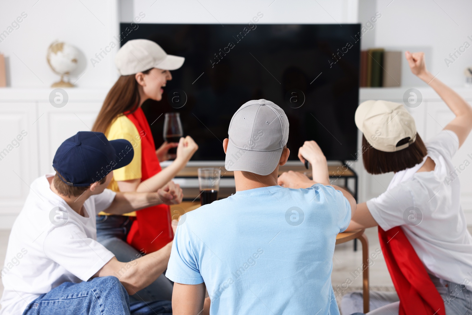Emotional sports fans watching game together indoors, selective focus Photo of Emotional sports fans watching game together indoors, selective focus