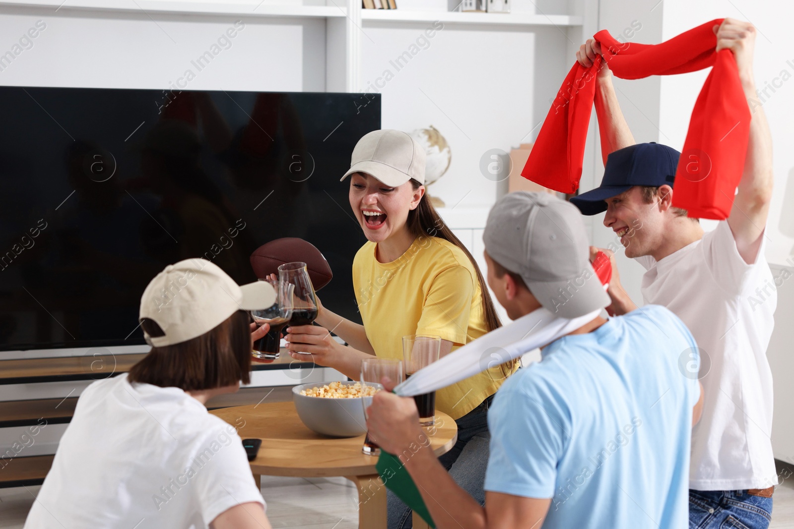 Emotional sports fans with drinks celebrating victory indoors Photo of Emotional sports fans with drinks celebrating victory indoors