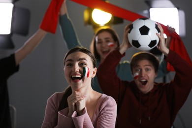 Photo of Emotional sports fans watching game together indoors, selective focus