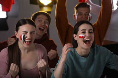 Photo of Emotional sports fans watching game together indoors, selective focus