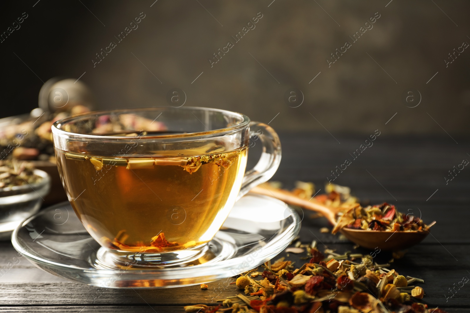 Refreshing herbal tea and dry leaves on black wooden table, closeup. Space for text Photo of Refreshing herbal tea and dry leaves on black wooden table, closeup. Space for text