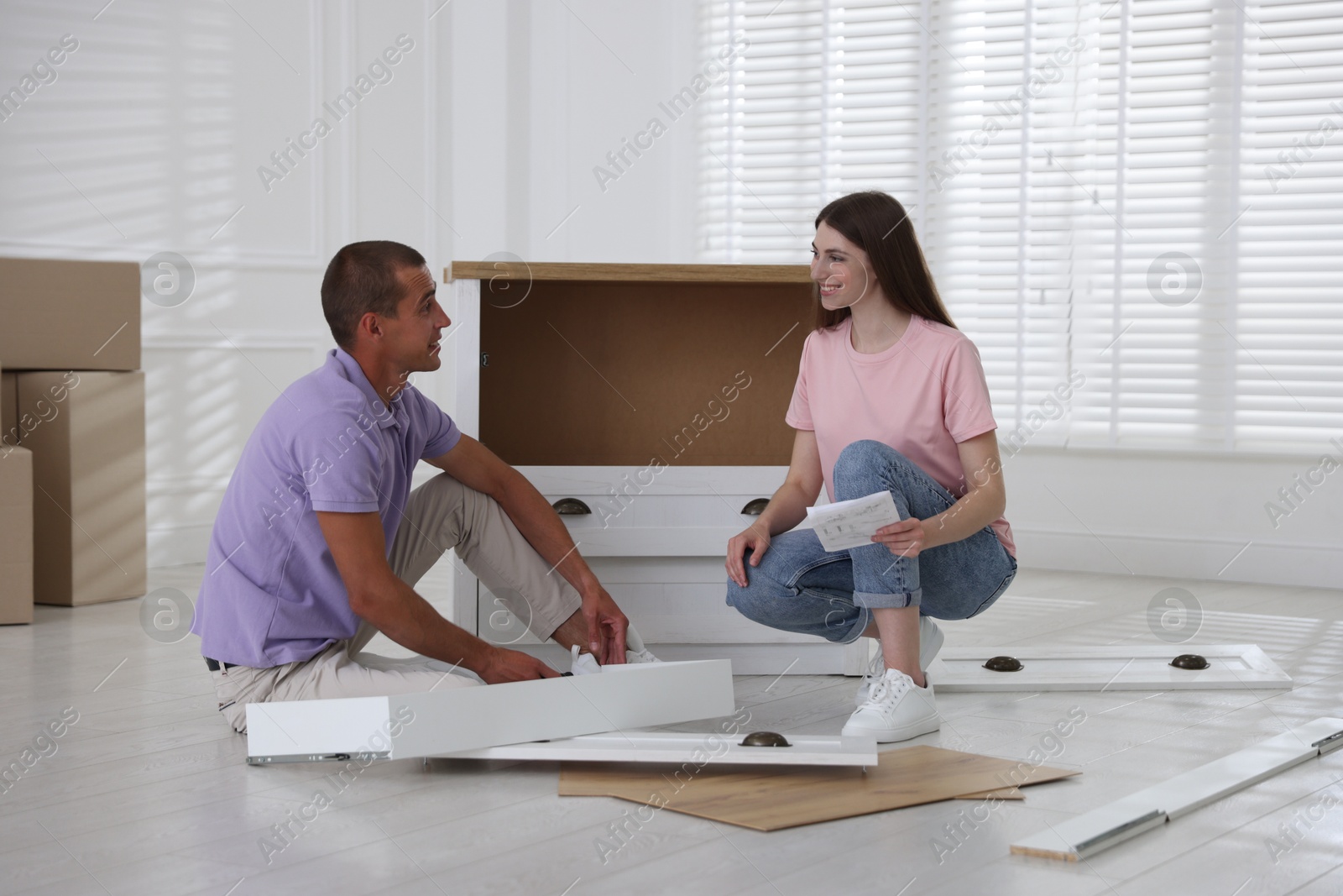 Happy couple with manual assembling furniture on floor at home Photo of Happy couple with manual assembling furniture on floor at home