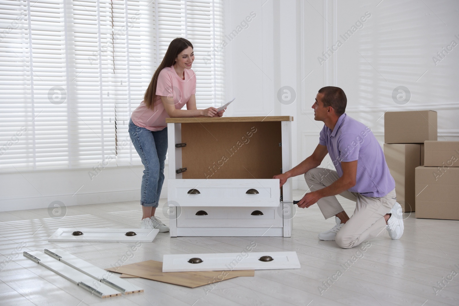 Happy couple with manual assembling furniture on floor at home Photo of Happy couple with manual assembling furniture on floor at home