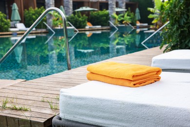 Photo of Sun loungers near outdoor swimming pool at luxury resort