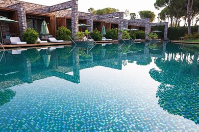 Photo of Outdoor swimming pool with umbrellas and sunbeds at resort