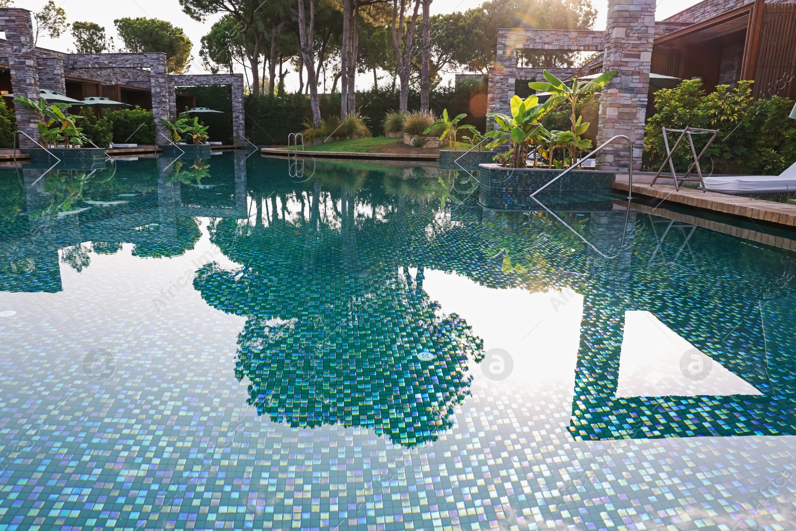Outdoor swimming pool with umbrellas and sunbeds at resort Photo of Outdoor swimming pool with umbrellas and sunbeds at resort