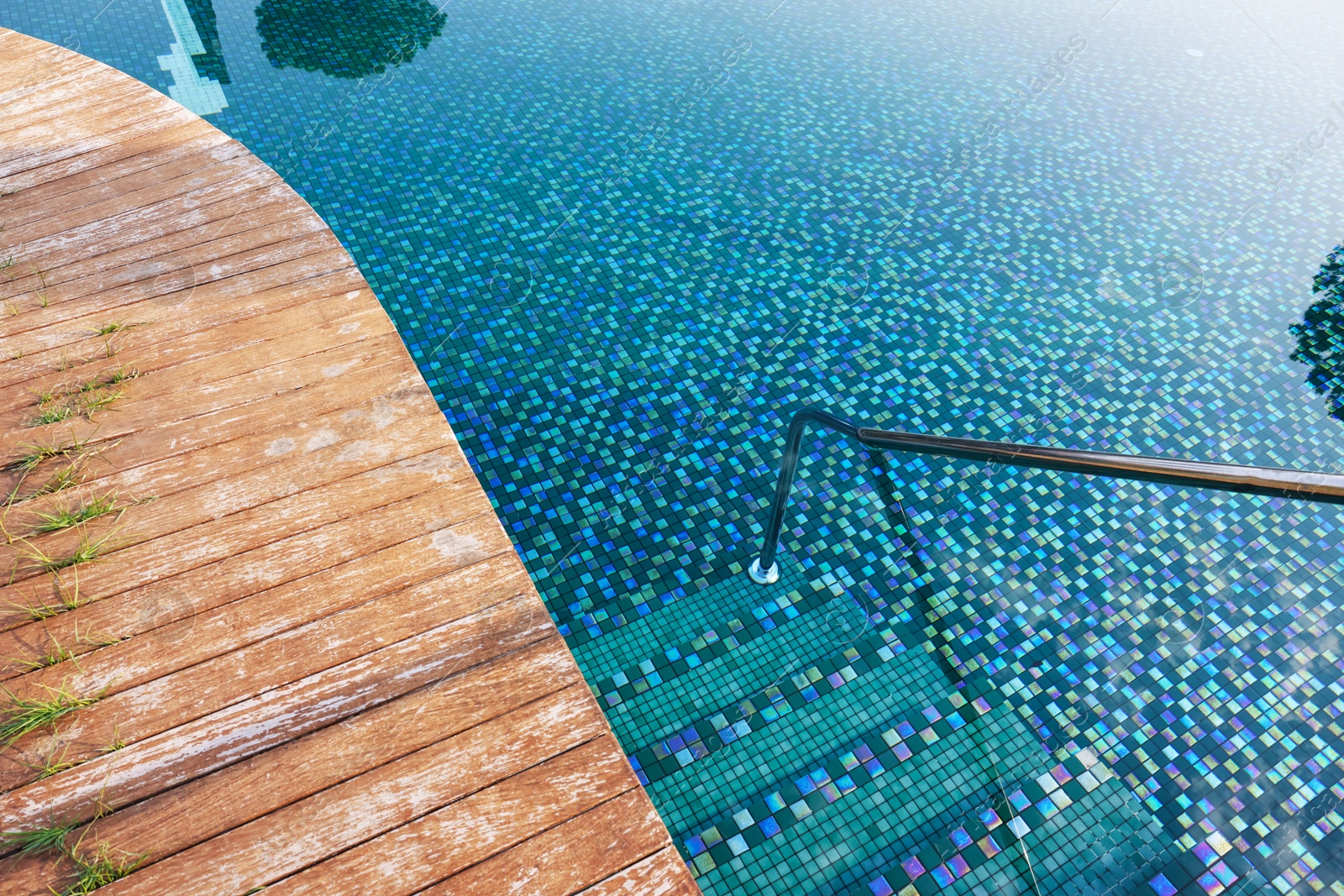 Outdoor swimming pool with steps and rail at resort Photo of Outdoor swimming pool with steps and rail at resort