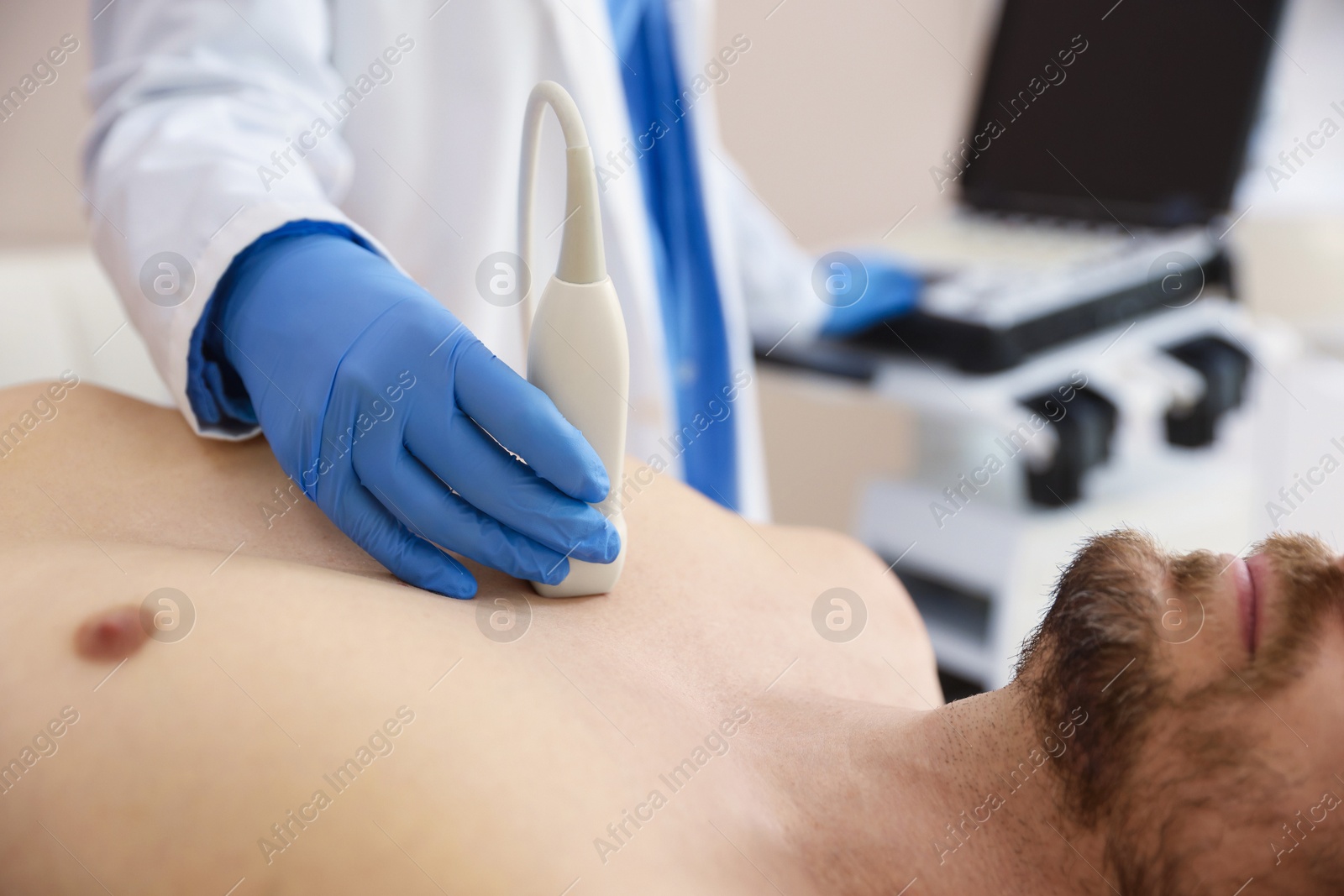 Sonographer conducting ultrasound examination of man's heart in clinic, closeup Photo of Sonographer conducting ultrasound examination of man's heart in clinic, closeup