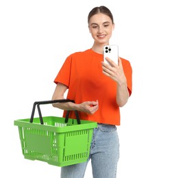 Photo of Woman with plastic shopping basket and smartphone on white background