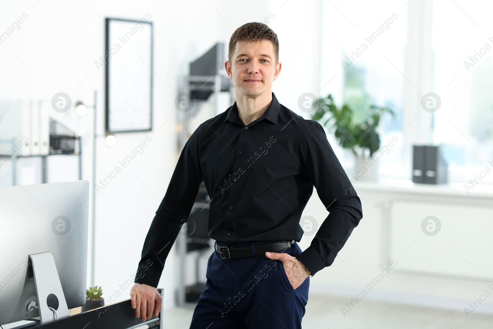 Portrait of handsome man near desk in office Photo of Portrait of handsome man near desk in office