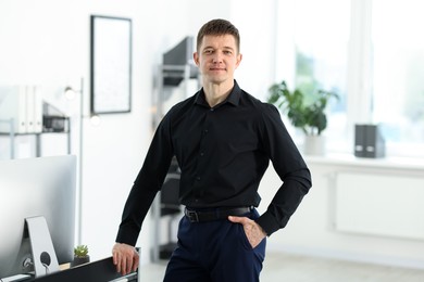 Photo of Portrait of handsome man near desk in office