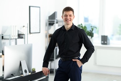 Photo of Portrait of handsome man near desk in office
