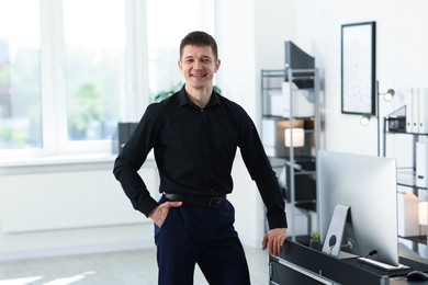 Photo of Portrait of handsome man near desk in office