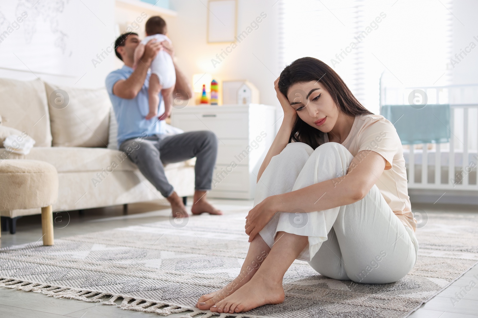 Woman suffering from postpartum depression and her husband with baby at home, selective focus Photo of Woman suffering from postpartum depression and her husband with baby at home, selective focus