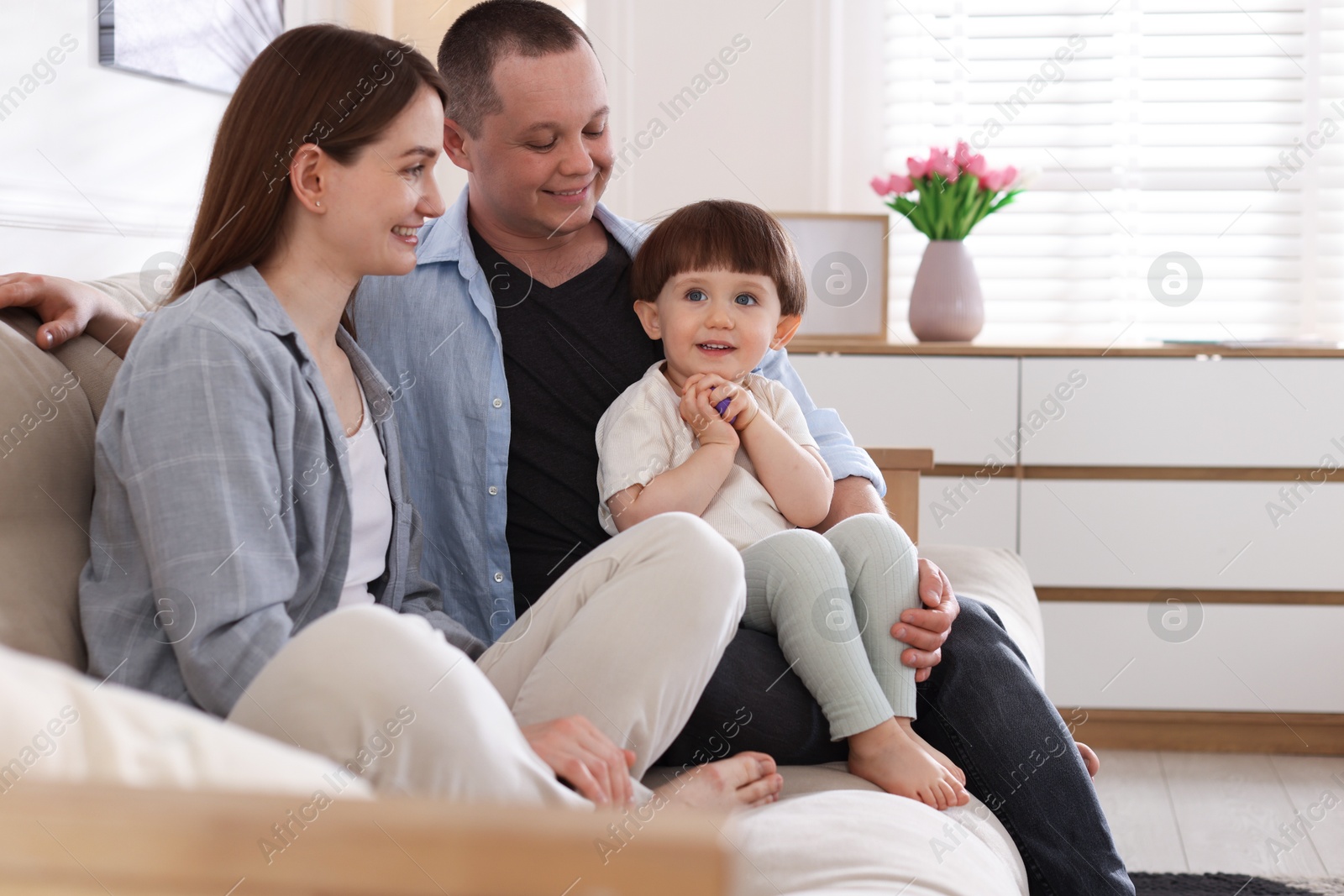 Photo of Cute little boy and his parents on sofa at home. Lovely family