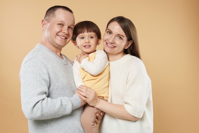 Photo of Happy parents and their baby boy on beige background. Lovely family