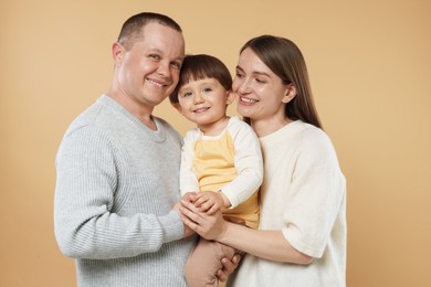 Photo of Happy parents and their baby boy on beige background. Lovely family