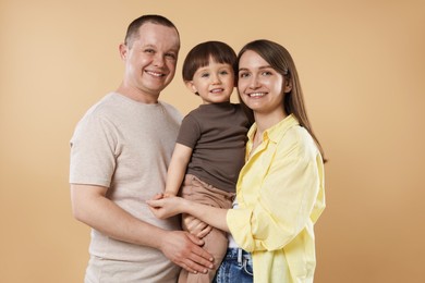 Photo of Happy parents and their baby boy on beige background. Lovely family