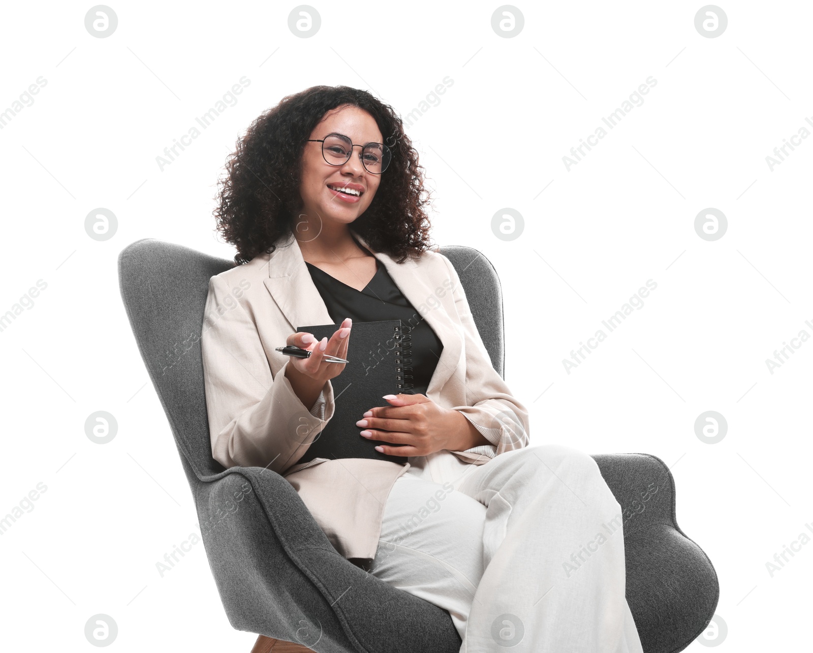 Professional psychologist with notebook and pen in armchair on white background Photo of Professional psychologist with notebook and pen in armchair on white background