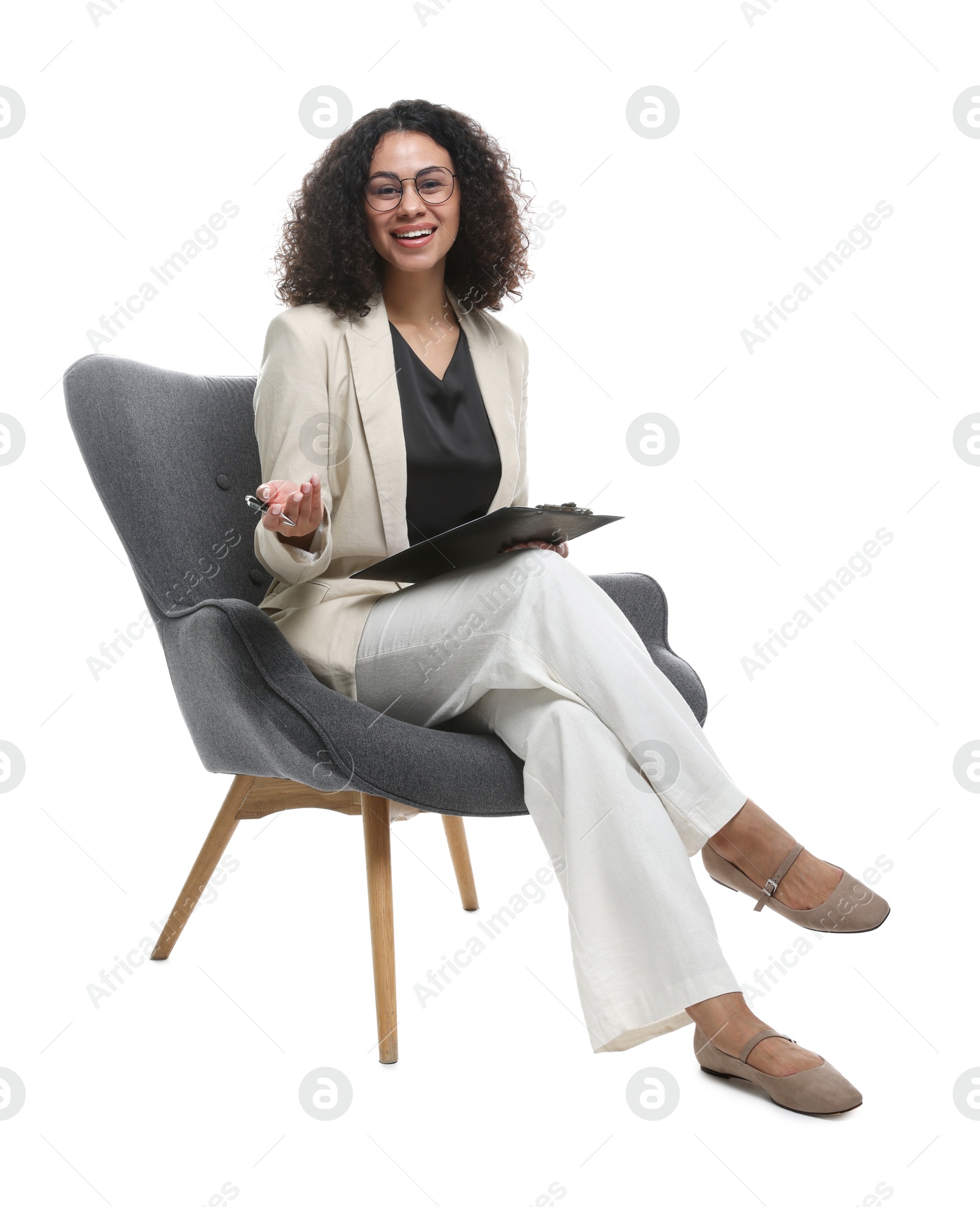 Professional psychologist with clipboard and pen in armchair on white background Photo of Professional psychologist with clipboard and pen in armchair on white background
