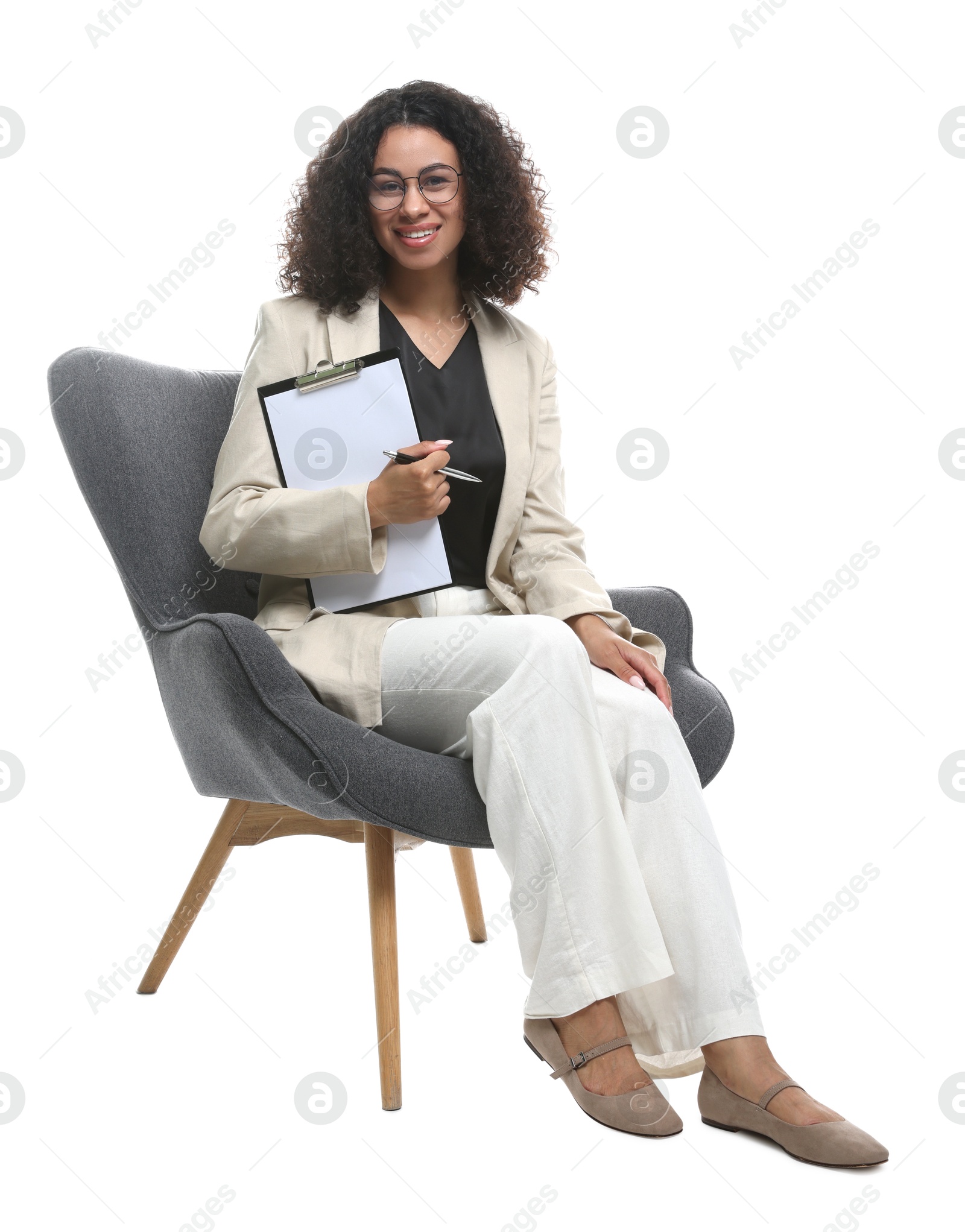 Professional psychologist with clipboard and pen in armchair on white background Photo of Professional psychologist with clipboard and pen in armchair on white background