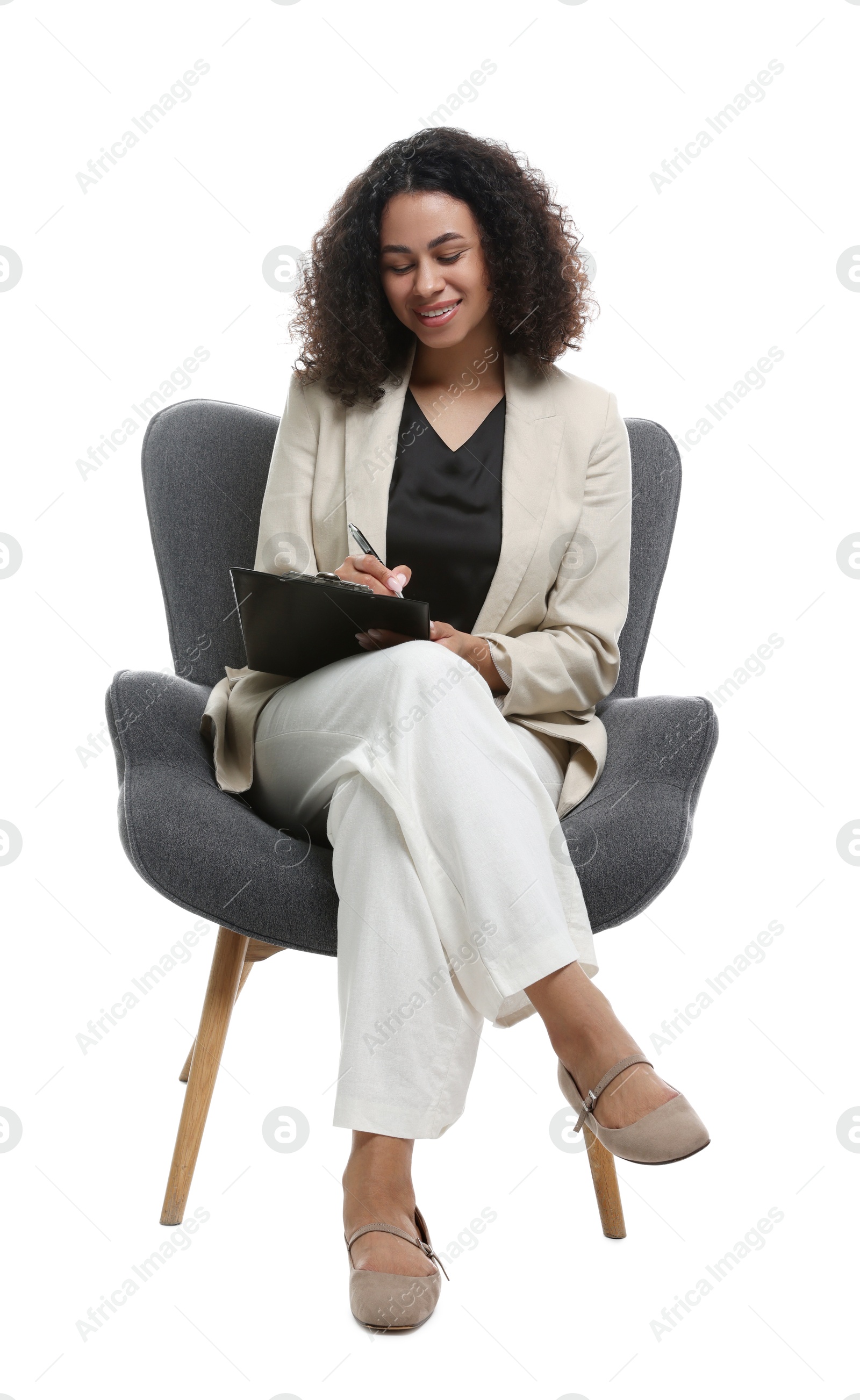 Professional psychologist with clipboard and pen in armchair on white background Photo of Professional psychologist with clipboard and pen in armchair on white background