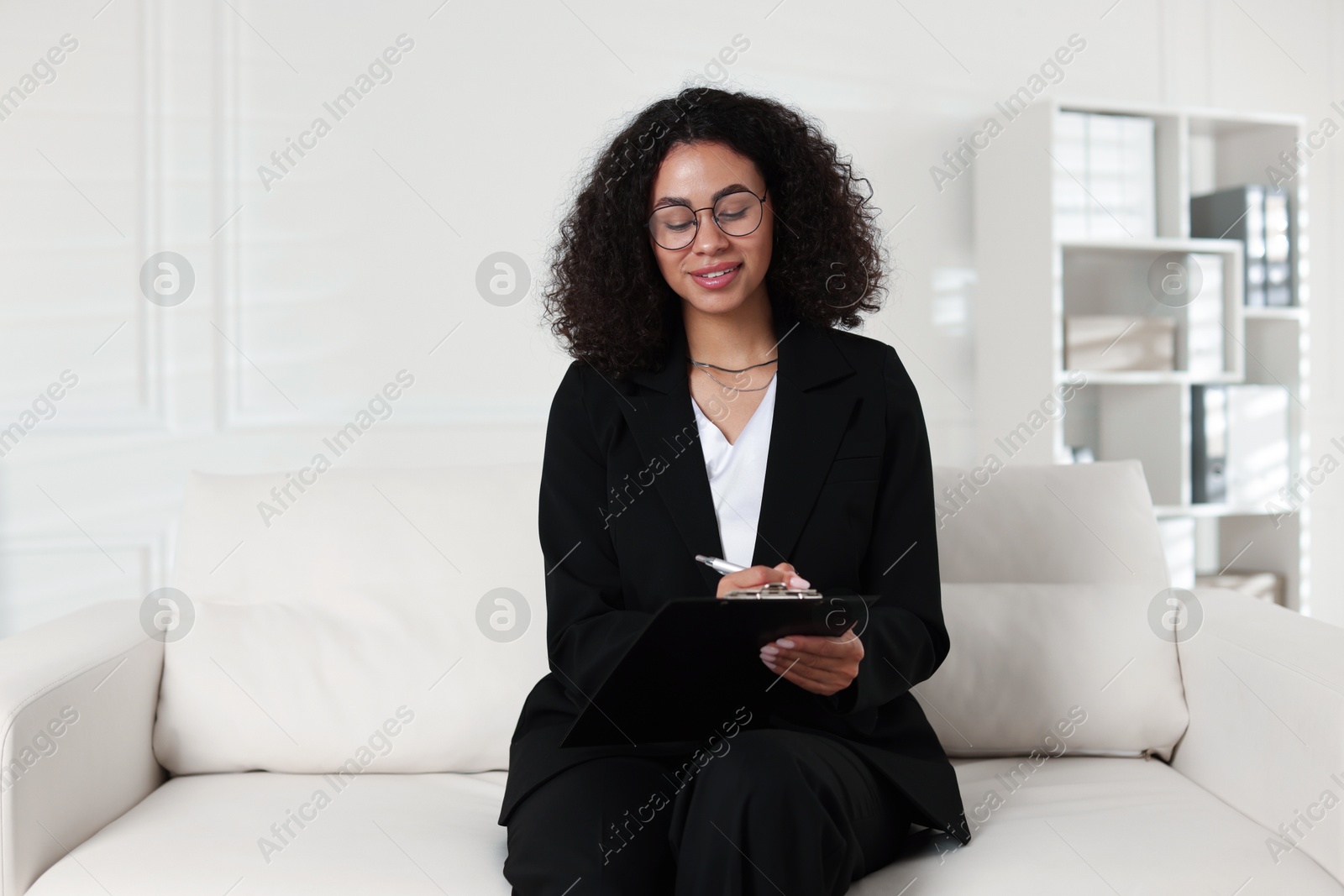 Professional psychologist with clipboard and pen in office Photo of Professional psychologist with clipboard and pen in office