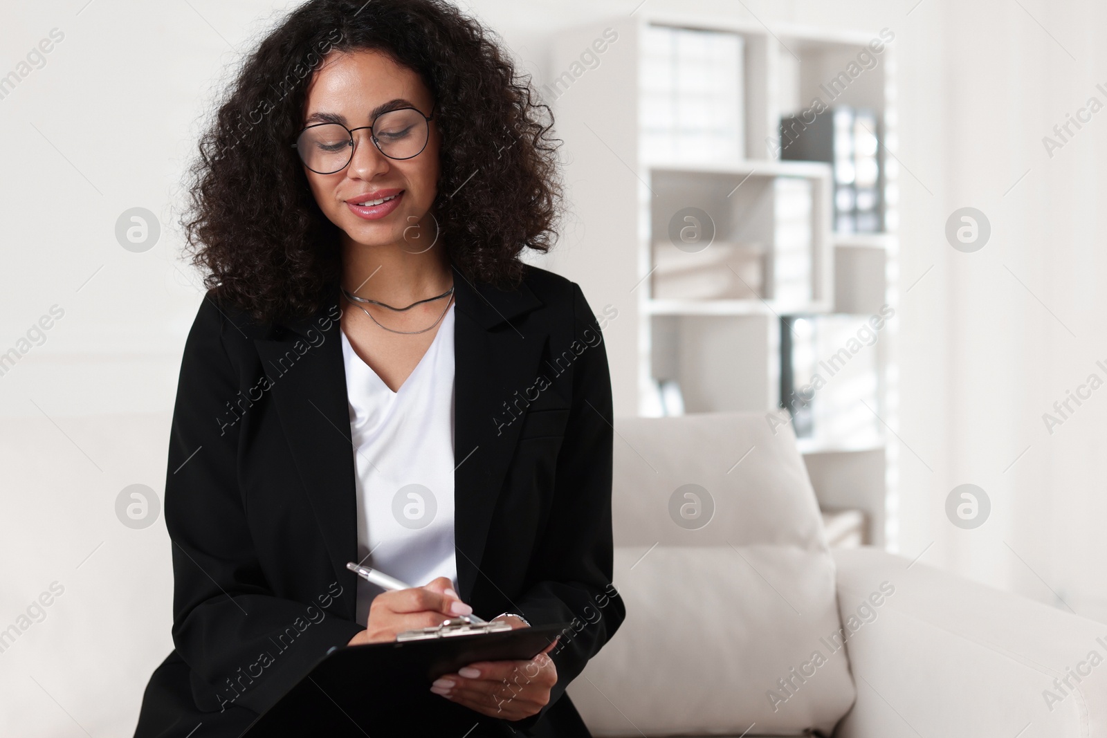 Professional psychologist taking notes in office, space for text Photo of Professional psychologist taking notes in office, space for text