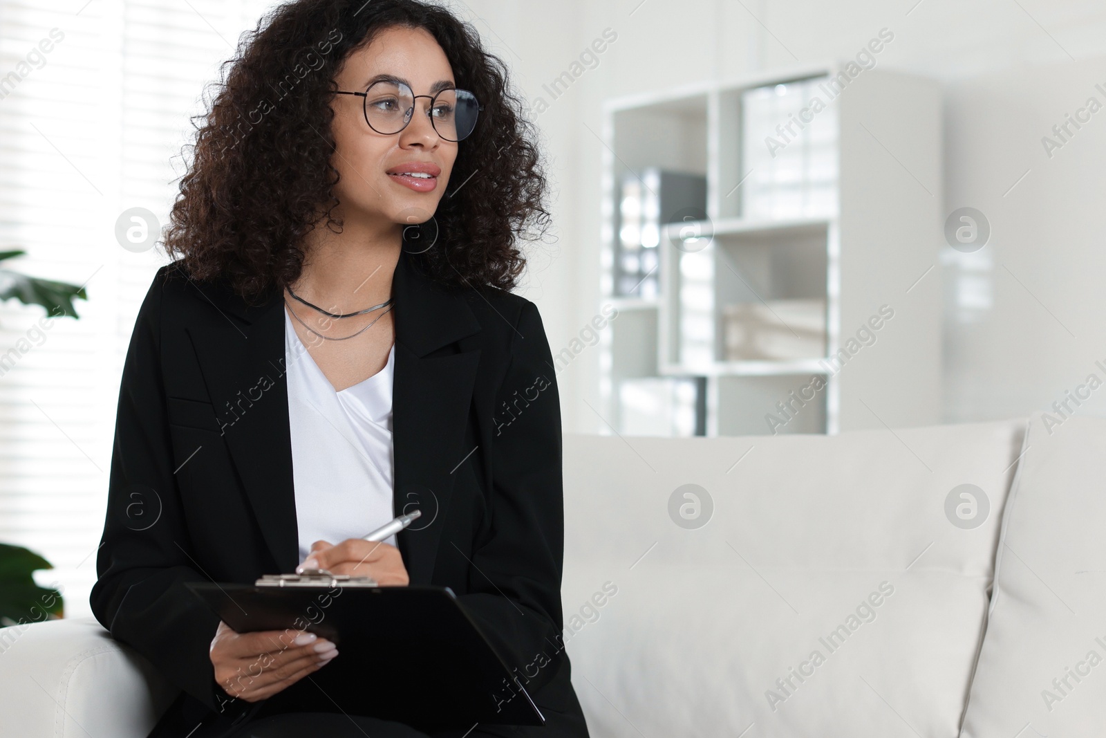 Professional psychologist with clipboard and pen in office, space for text Photo of Professional psychologist with clipboard and pen in office, space for text