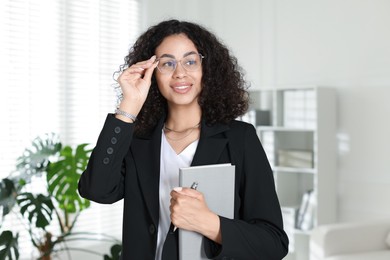 Photo of Professional psychologist with notebook and pen in office