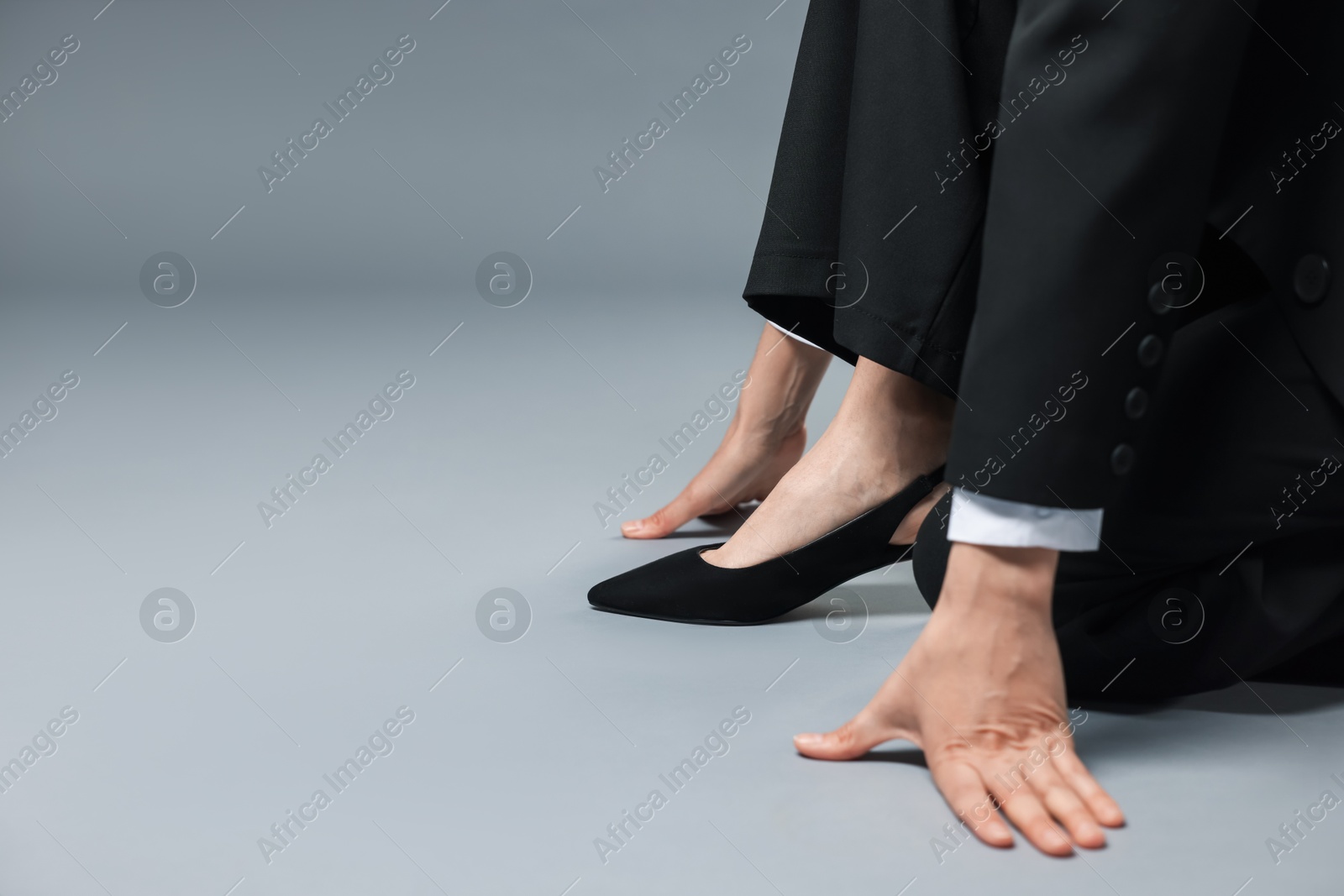 Businesswoman in starting position on gray background, closeup. Space for text Photo of Businesswoman in starting position on gray background, closeup. Space for text