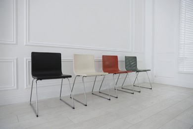 Photo of Colorful chairs near white wall in waiting room