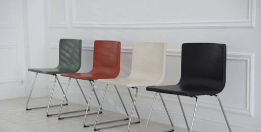 Photo of Colorful chairs near white wall in waiting room