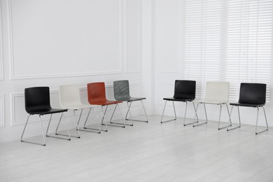 Photo of Colorful chairs near white wall in waiting room