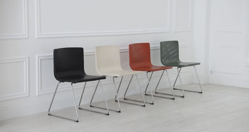 Photo of Colorful chairs near white wall in waiting room