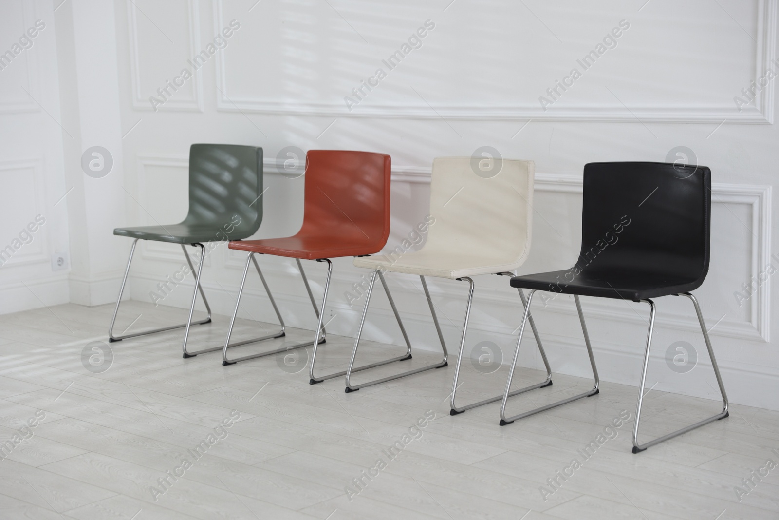 Colorful chairs near white wall in waiting room Photo of Colorful chairs near white wall in waiting room