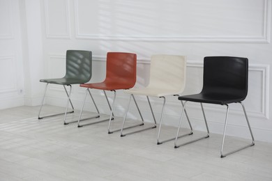 Photo of Colorful chairs near white wall in waiting room