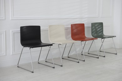 Photo of Colorful chairs near white wall in waiting room